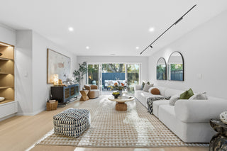 Modern living room with white sofa, coffee table, and decorative items.