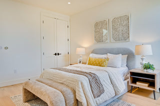 Modern bedroom with a bed, nightstands, and wall art.