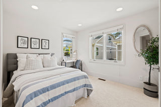 Neatly arranged bedroom with a bed, side table, and decor.