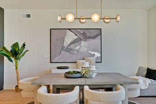 Modern dining room with a gray table, chairs, and abstract art on the wall.