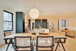 Modern living room with a dining table and chairs, kitchen in the background