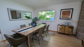 Dining room with wooden table, chairs, and decor elements.