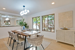 Dining room with wooden table, chairs, and decorative elements.