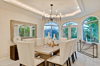 Dining room with a large window, chandelier, and decorative items.