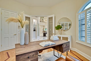 Home office with wooden desk, book, and decorative items.