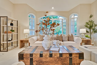 Modern living room with a large wooden coffee table, beige sofa, and decorative elements.