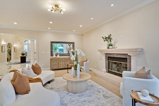 Modern living room with white furniture, fireplace, and decorative elements.