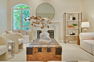 Living room with a wooden coffee table, decorative items, and a fireplace.