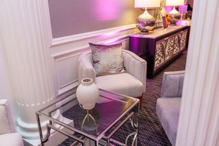 Modern living room with gray sofa, glass coffee table, and decorative elements.