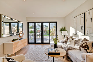Modern living room with a couch, coffee table, and large windows.