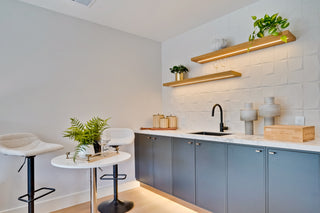 Modern kitchen with gray cabinets, white countertops, and decorative elements.
