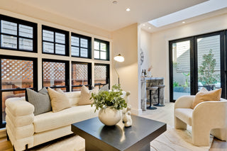 Modern living room with beige sofa, coffee table, and decorative elements.