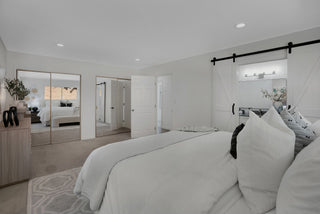 Gorgeous bedroom with white bedding and decor and glass door window