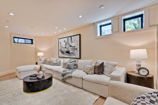 Modern living room with beige sofa, coffee table, and decorative elements.