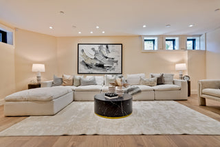 Modern living room with beige sectional sofa, coffee table, and decorative elements.