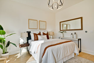 Modern bedroom with a bed, side tables, and decorative elements.