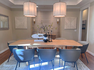 Dining room with a wooden table and blue chairs, featuring a neutral color scheme.