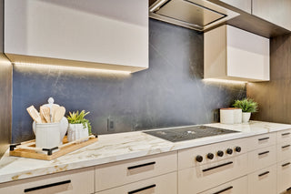 Modern kitchen with stainless steel appliances and marble countertops.