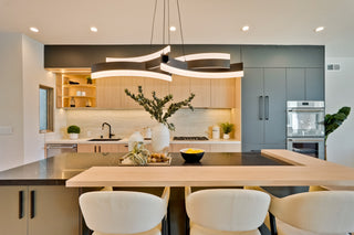Modern kitchen with island, chairs, and decorative elements.