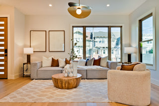 Modern living room with gray sofa, beige armchair, and wooden coffee table.