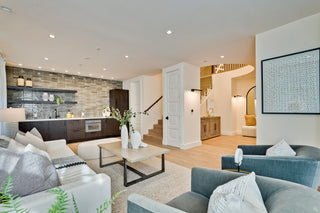 Modern living room with gray and blue sofas, coffee table, and decorative elements.