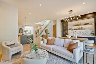 Modern living room with white sofa, armchair, and decorative elements.