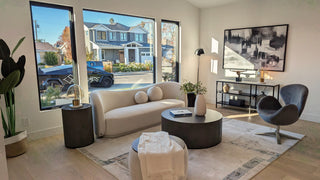 Attractive living room with white sofas, decorative pillows, and a round coffee table with a plant.  creating a serene