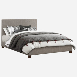 A gray upholstered queen-sized platform bed with a headboard, footboard, slats, and rails, with a bedsheet and multiple pillows on it.
