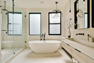 Modern bathroom with a freestanding bathtub, sink, and large mirror.