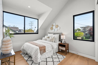 Modern bedroom with large windows, bed, and decorative elements.