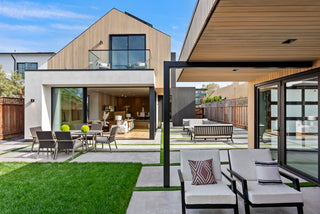Modern house exterior with outdoor furniture and green lawn