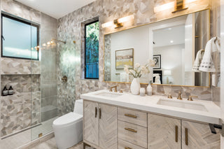 Modern bathroom with marble walls, a vanity, and a shower.