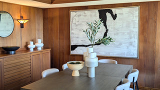 Modern beddroom with and bed, nightstands, and artwork on a white wall.