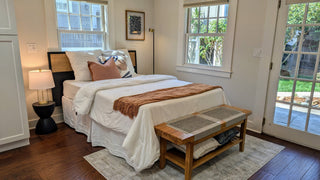 Modern beddroom with and bed, nightstands, and artworks onn a white wall.