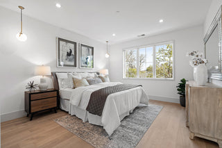 Modern bedroom with a bed, nightstands, and large windows.