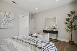 Modern_bedroom_walls_wood_flooring_a_bed_with_striped_bedding