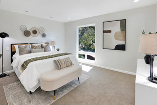 Modern bedroom with a bed, bench, and decorative elements and nice lamp stand