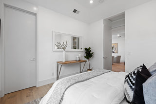 Modern bedroom with a bed, console table, and decorative elements.