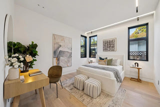 Modern bedroom with a bed, desk, and decorative elements.