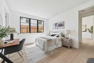 Modern bedroom with a bed, desk, and large window open door and inner room 