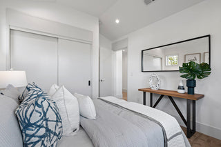 Modern bedroom with a bed, nightstand, and decorative elements.