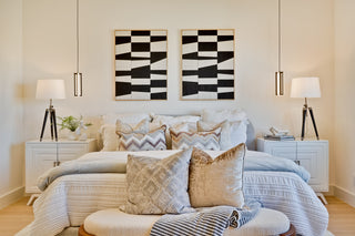 Modern bedroom with a bed, nightstands, and abstract wall art.