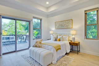 Modern bedroom with a bed, nightstands, and sliding glass door leading to a patio.