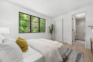 Modern bedroom with a bed, window, and wardrobe and stunning  bathroom
