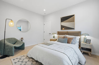 Modern bedroom with a bed, chair, and decor elements.