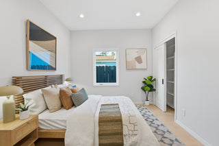 Modern bedroom with a bed, nightstands, and wall art.