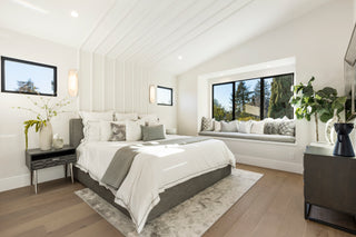 Modern bedroom with a large bed, nightstands, and a window seat.