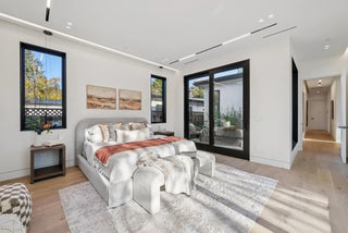 Modern bedroom with a large bed, side tables, and large windows glass wall 