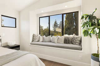 Modern bedroom with a window seat and view of trees