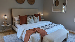 Modern bedroom with and bed, nightstands, and artwork on a white wall.